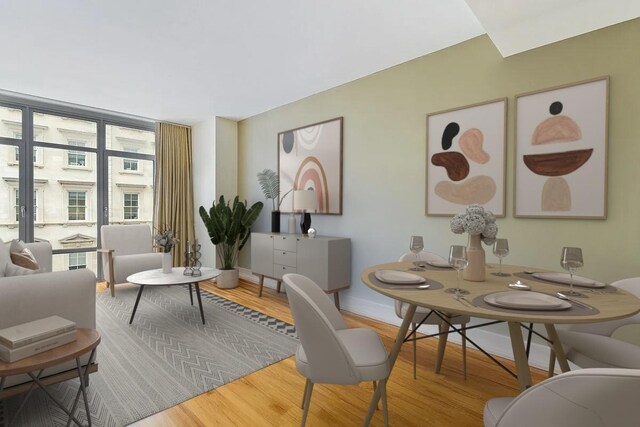 living room with a wall of windows and light hardwood / wood-style flooring