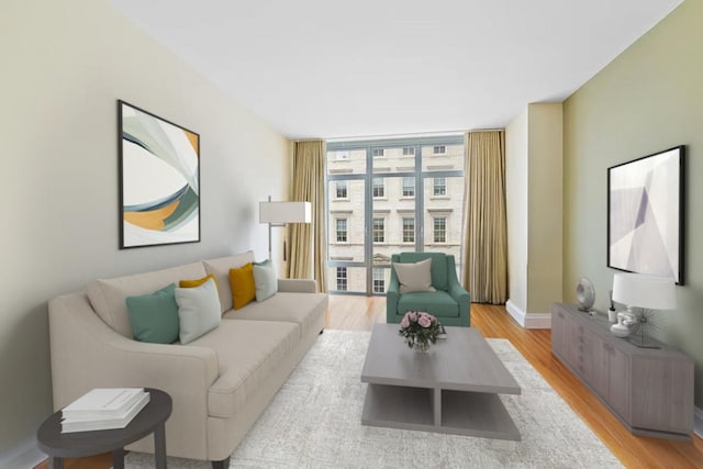 living room with light wood-style floors, expansive windows, and baseboards