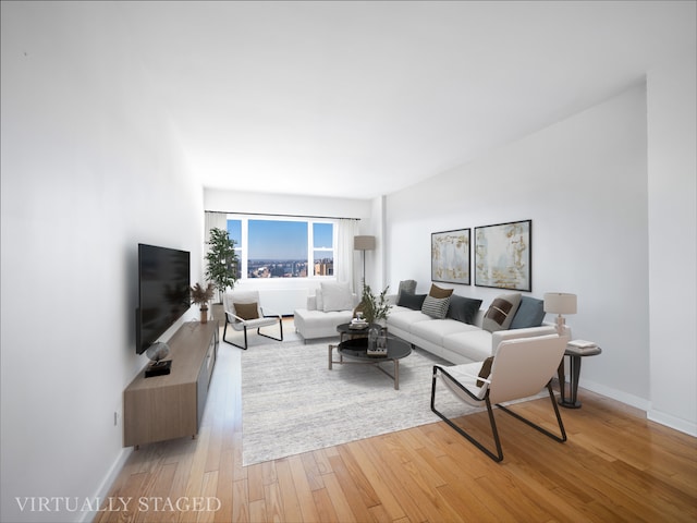 living area with light wood-style flooring and baseboards