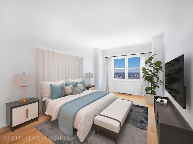 bedroom with hardwood / wood-style floors and radiator