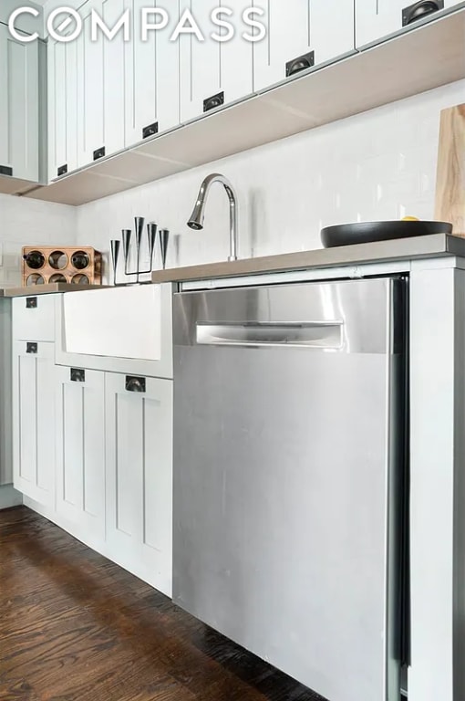 kitchen with stainless steel dishwasher, white cabinets, and dark hardwood / wood-style floors