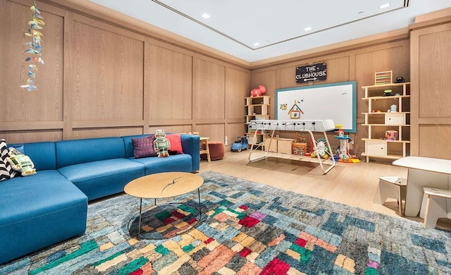 playroom featuring a decorative wall, recessed lighting, and wood finished floors