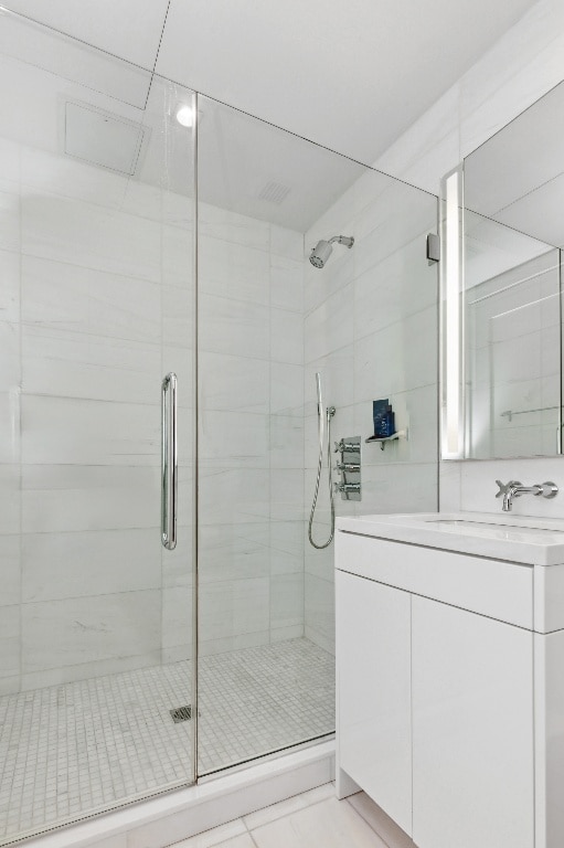 bathroom with vanity, a shower with door, and tile patterned floors