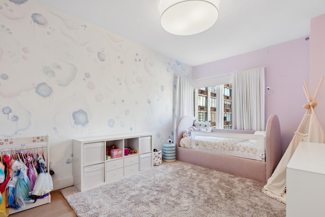 bedroom featuring wood finished floors and wallpapered walls
