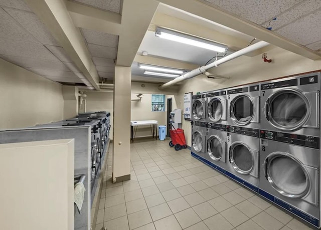 washroom with stacked washer / drying machine, light tile patterned flooring, and washer and clothes dryer