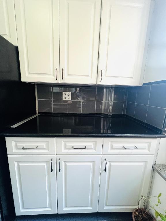 kitchen with white cabinets, dark stone countertops, and decorative backsplash