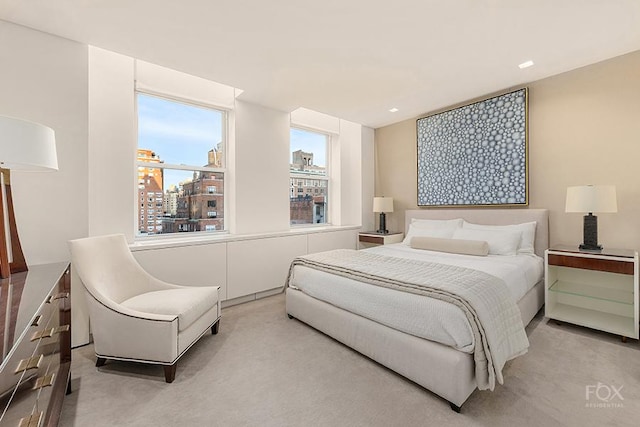 bedroom featuring light carpet and a view of city