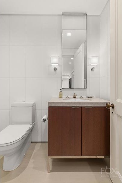 bathroom with tile patterned flooring, vanity, toilet, and tile walls