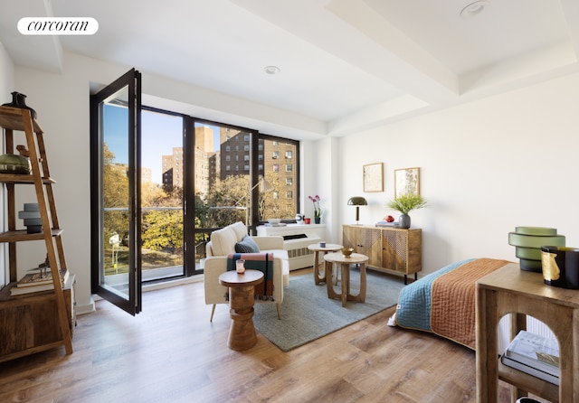 living room featuring light wood-type flooring and a tray ceiling