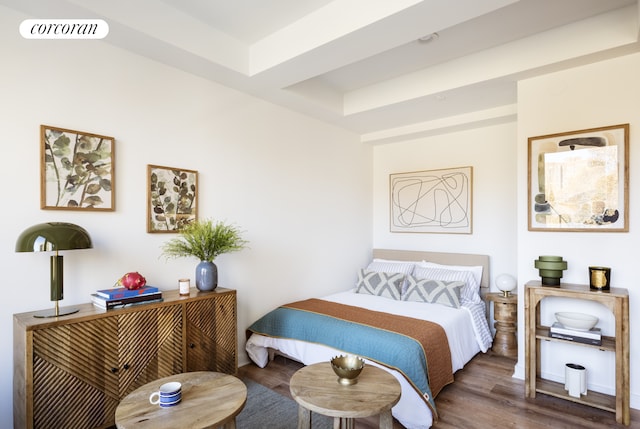 bedroom with visible vents, wood finished floors, and a raised ceiling