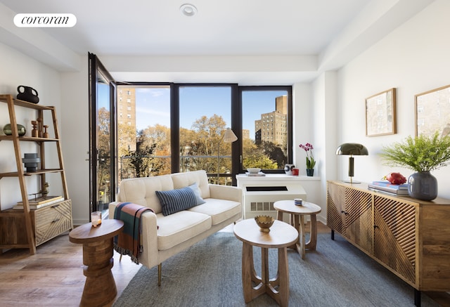 living area with wood finished floors, visible vents, and baseboards