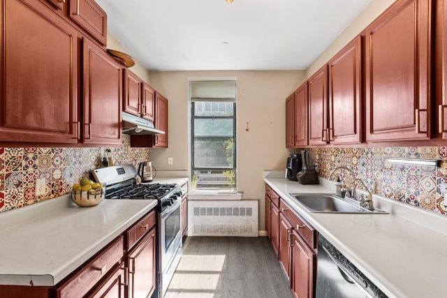 kitchen featuring sink, gas stove, wood-type flooring, radiator heating unit, and dishwasher