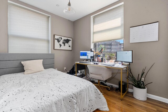 bedroom with wood finished floors and baseboards