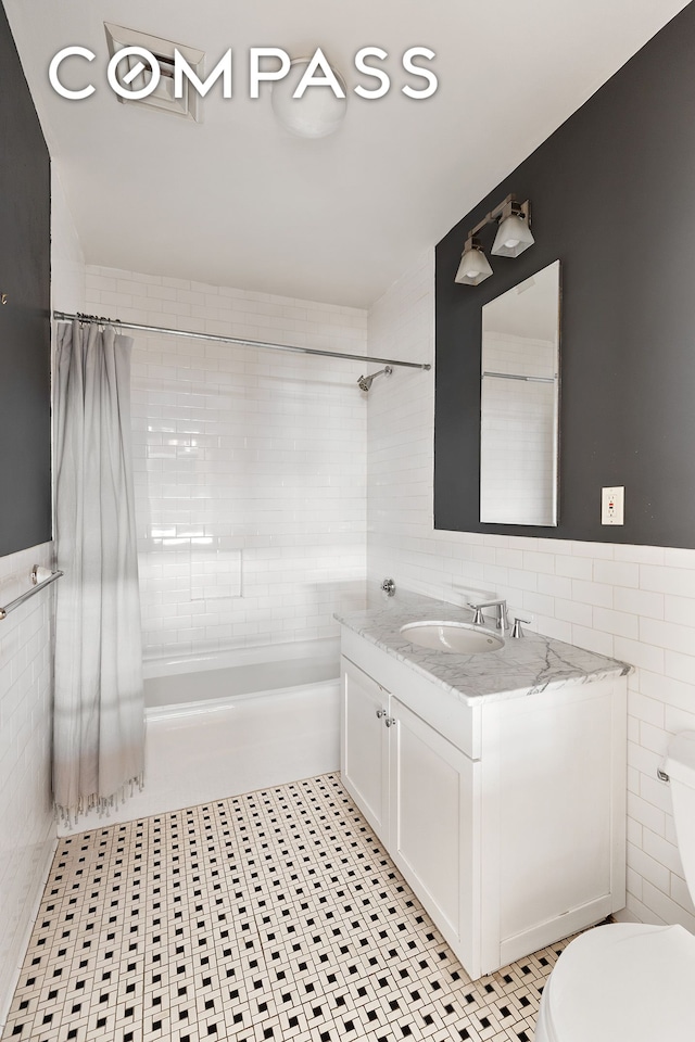 126 W 22nd St Unit 5N, New York City, NY 10011 - full bathroom with tile walls, toilet, shower / bath combination with curtain, vanity, and tile patterned floors