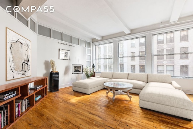 living room featuring beamed ceiling, hardwood / wood-style floors, and a wealth of natural light