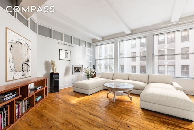 126 W 22nd St Unit 5N, New York City, NY 10011 - living room featuring beamed ceiling, wood finished floors, and baseboards