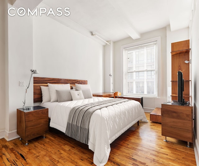 126 W 22nd St Unit 5N, New York City, NY 10011 - bedroom featuring light wood-style flooring, beamed ceiling, and baseboards