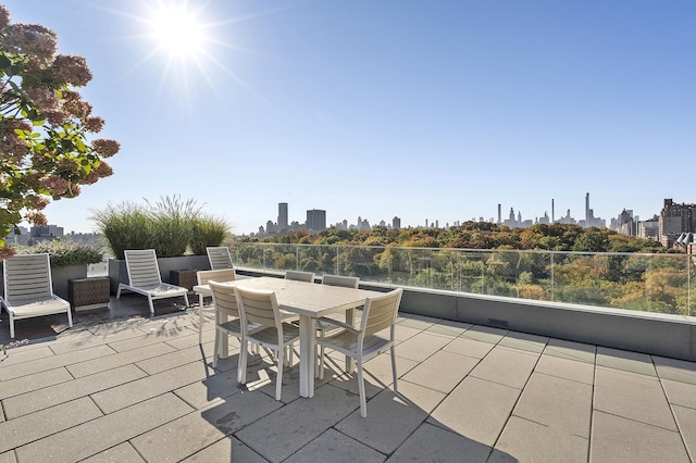 view of patio featuring outdoor dining area and a view of city