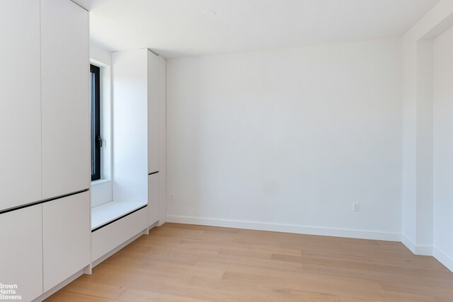 living area featuring light wood finished floors, baseboards, and french doors