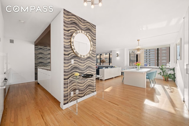 30 W 61st St Unit 9C, New York City, NY 10023 - hallway featuring a chandelier and light wood-type flooring