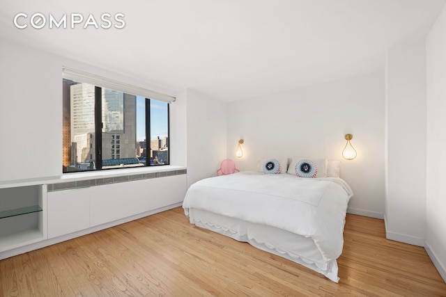 30 W 61st St Unit 9C, New York City, NY 10023 - bedroom featuring light wood-style floors and baseboards