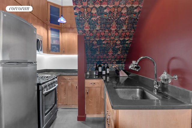 kitchen featuring hanging light fixtures, appliances with stainless steel finishes, sink, and light tile patterned flooring