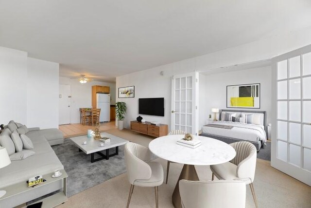 carpeted living room featuring ceiling fan and french doors