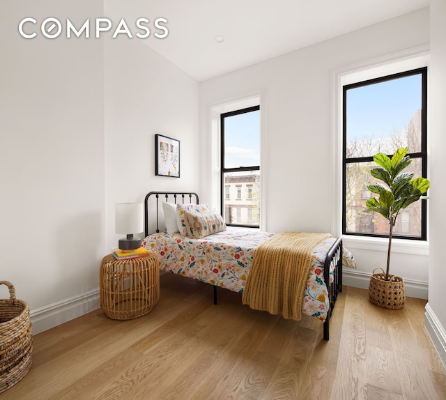 bedroom with baseboards and wood finished floors