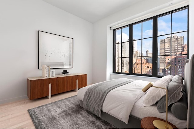 bedroom with light wood-type flooring and multiple windows