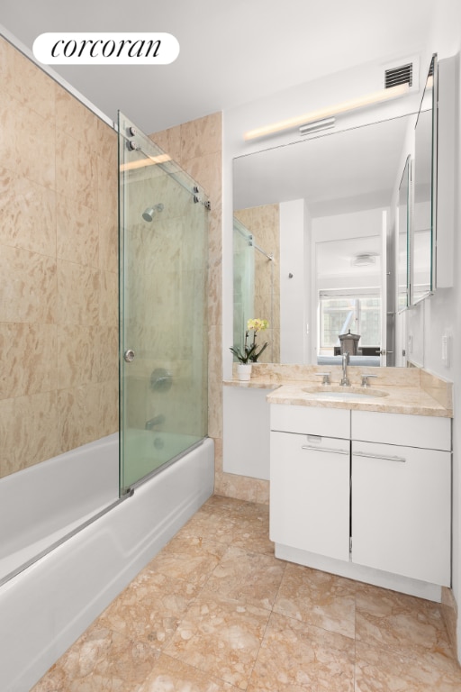 bathroom with combined bath / shower with glass door and vanity