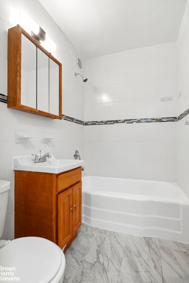 full bathroom featuring toilet, marble finish floor, vanity, tile walls, and shower / bathing tub combination