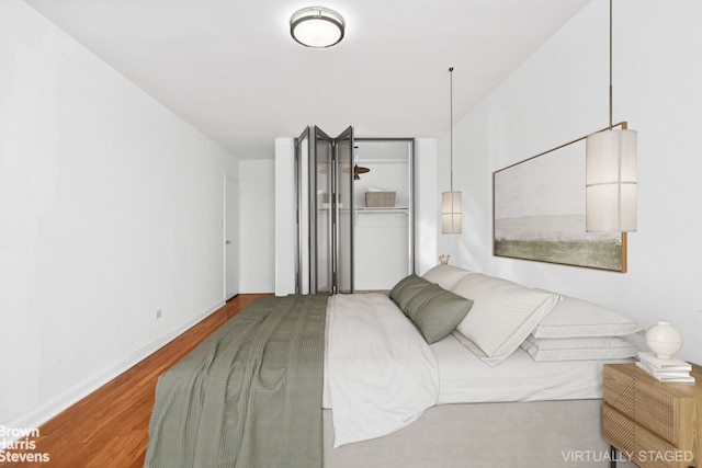 bedroom featuring wood finished floors and baseboards