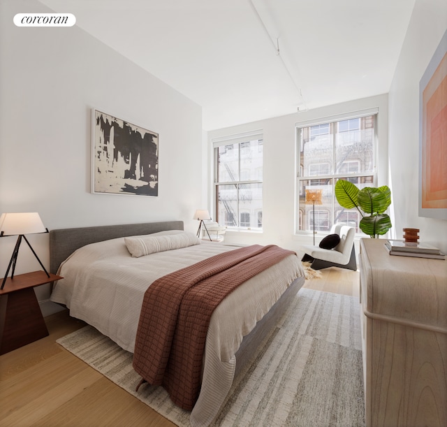 bedroom with visible vents, multiple windows, and light wood-style flooring