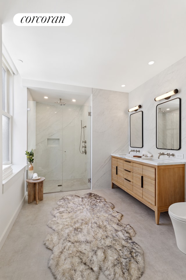 full bathroom featuring double vanity, a marble finish shower, and recessed lighting