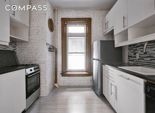 kitchen featuring appliances with stainless steel finishes, dark countertops, white cabinets, and open shelves