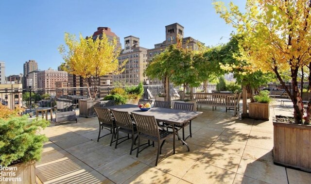 view of patio / terrace featuring a view of city and outdoor dining space