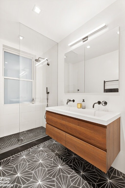 bathroom featuring double vanity and walk in shower