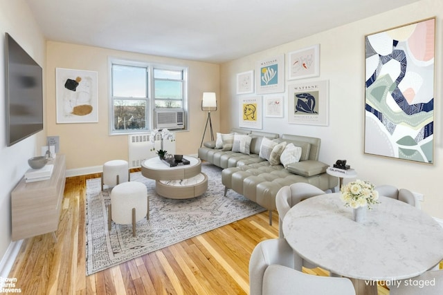 living room featuring light hardwood / wood-style flooring, cooling unit, and radiator heating unit