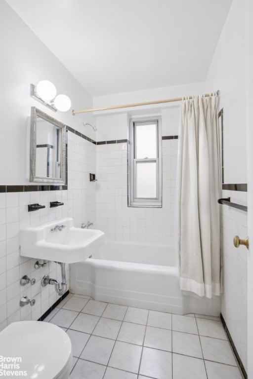 bathroom with tile walls, shower / tub combo, tile patterned floors, and toilet