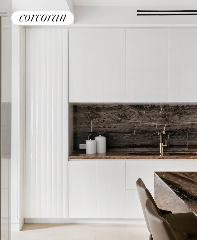 kitchen featuring backsplash, dark countertops, modern cabinets, and white cabinets