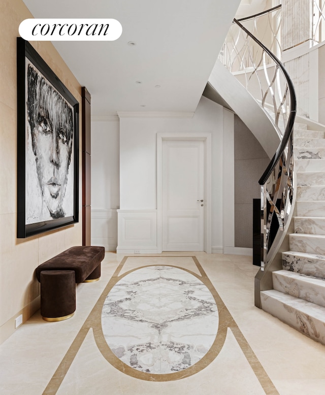 entrance foyer featuring marble finish floor, crown molding, stairway, and baseboards