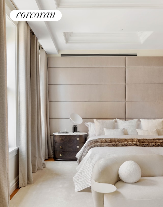 bedroom featuring ornamental molding, a raised ceiling, and light colored carpet