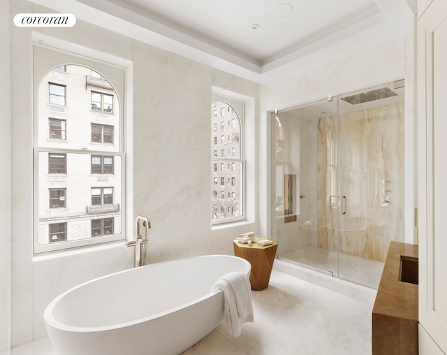 full bathroom with a freestanding tub, vanity, and a marble finish shower