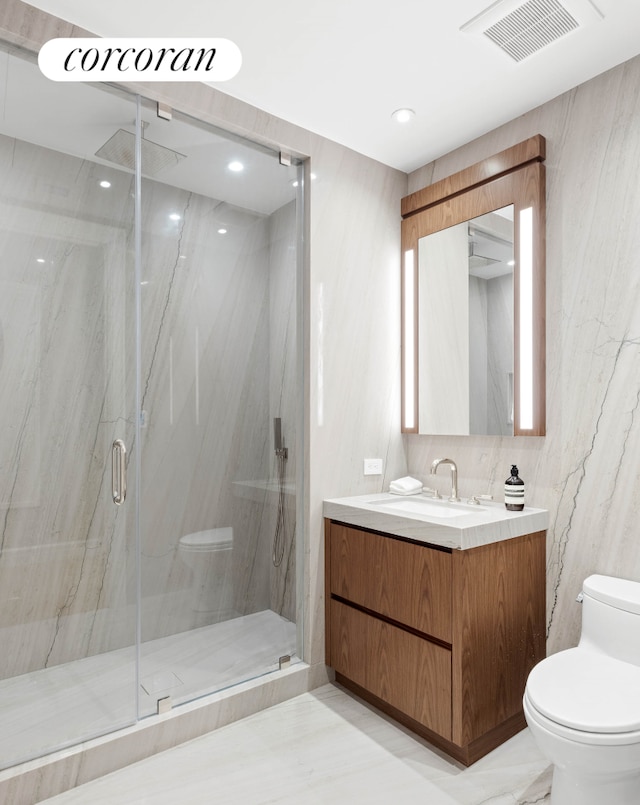 full bath with marble finish floor, a marble finish shower, visible vents, toilet, and vanity