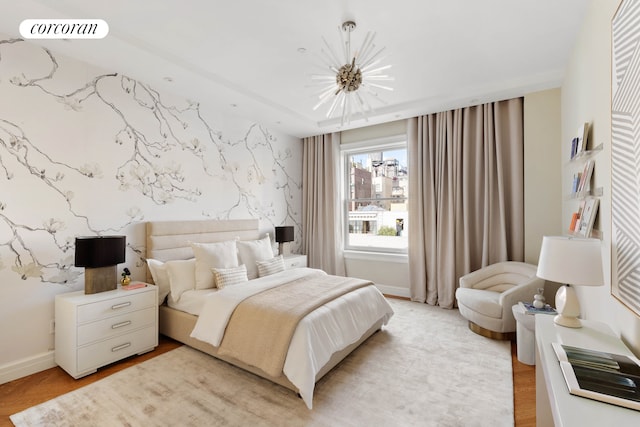 bedroom with visible vents, an inviting chandelier, an accent wall, baseboards, and wallpapered walls