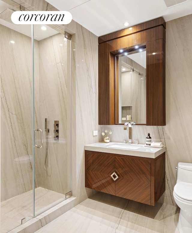 bathroom featuring a marble finish shower, toilet, and vanity