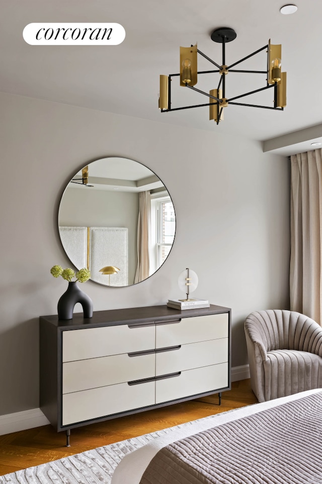 bedroom featuring wood finished floors, a notable chandelier, and baseboards