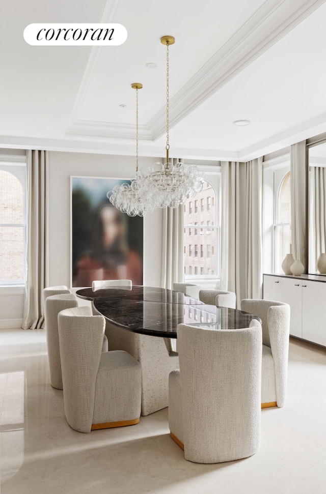 dining area with ornamental molding and a raised ceiling