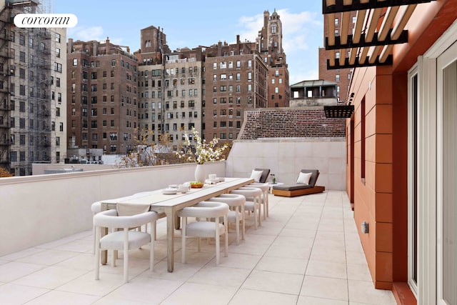 view of patio with outdoor dining area and a city view