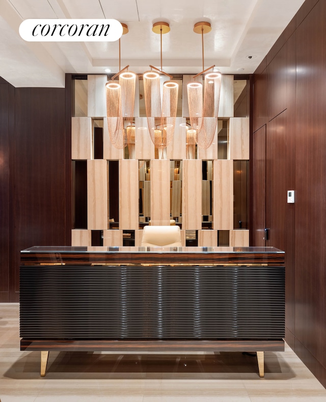 interior space with wood walls and a tray ceiling